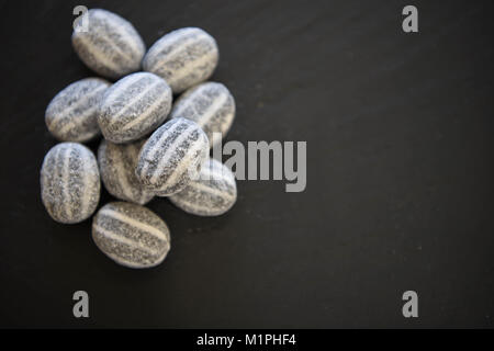 Essen von Süßigkeiten behandelt oder Süßigkeit Zucker überzogen und Pfefferminz Geschmack und zäh Center, Aufschneider, einem altmodischen Streifen Süße Stockfoto