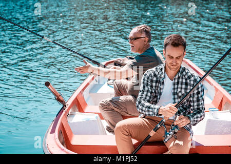 Mann mit Oldie Fischen vom Ruderboot Stockfoto