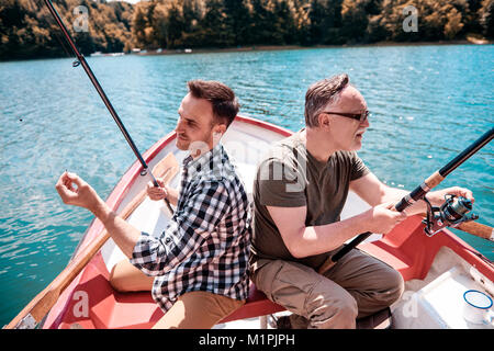 Zwei Männer sitzen, angeln und Kanu Stockfoto