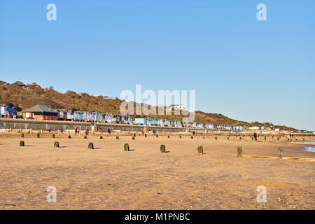 Menschen zu Fuß entlang Frinton Strand an einem sonnigen Tag Stockfoto