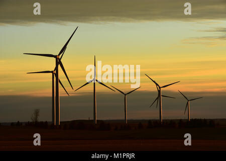 Windenergieanlage Farm produzieren sauberen Strom aus erneuerbaren Energien in North Dakota bei Sonnenuntergang. Stockfoto