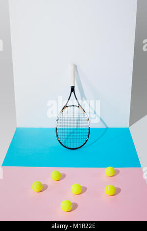 Gelbe Tennisbälle auf Blau und Rosa Papiere Stockfoto