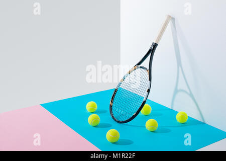 Gelbe Tennisbälle auf Blau und Rosa Papiere Stockfoto