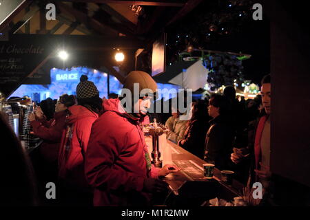 Kunden, heiße Getränke von außerhalb Stall während eines kalten Abend am Hyde Park Winter Wonderland. Stockfoto