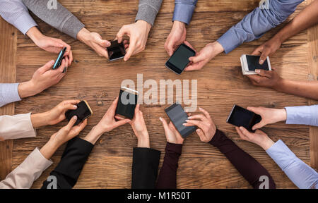 Hohe Betrachtungswinkel der Geschäftsleute, die Hand mit Handy Stockfoto