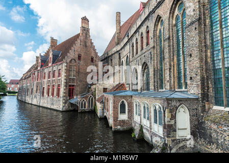 Alte traditionelle Häuser entlang des Flusses in der mittelalterlichen Stadt Brügge, Belgien. Stockfoto