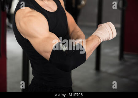 Nahaufnahme eines Athleten Person tragen Verband am Ellenbogen in der Turnhalle Stockfoto