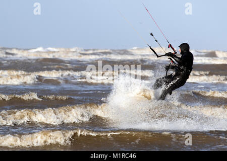 Southport, Merseyside. 1 Feb, 2018. UK Wetter. Kite Surfer springt und in der Luft, als die starken Winde zerschlagen, die Küste mit Ebbe für den Start einer neuen Winter Monat. Die Temperaturen sind Prognose noch weiter als Nordwind Sweep in zu fallen. Kredit; MediaWorldImages/AlamyLiveNews Stockfoto