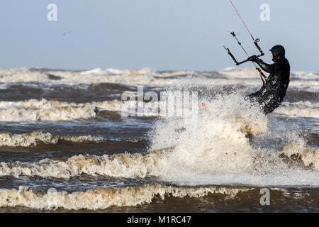 Southport, Merseyside. 1 Feb, 2018. UK Wetter. Kite Surfer springt und in der Luft, als die starken Winde zerschlagen, die Küste mit Ebbe für den Start einer neuen Winter Monat. Die Temperaturen sind Prognose noch weiter als Nordwind Sweep in zu fallen. Kredit; MediaWorldImages/AlamyLiveNews Stockfoto