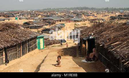 März 24, 2017 - Cox's Bazar, Bangladesch - Ein junger Rohingya Kind saß auf einem der vielen verschlungenen Pfade, die sich ihren Weg durch Kutupalong camp Weben. Mehr als 600.000 Rohingya Flüchtlinge aus Myanmar Rakhine flohen seit August 2017, als die meisten von ihnen versuchen, die Grenze Bangladesch jeden Tag zu erreichen zu halten. Quelle: John Owens/SOPA/ZUMA Draht/Alamy leben Nachrichten Stockfoto