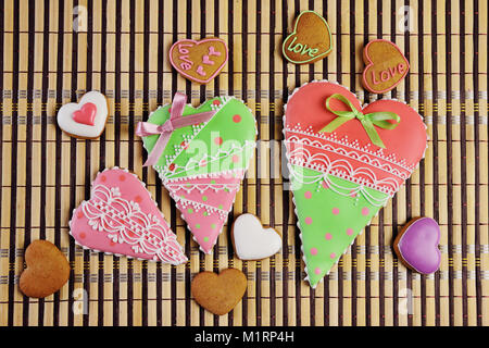 Lebkuchen Kekse in der Form eines Herzens mit farbige Glasur auf ein Close-up Tisch gemalt. Stockfoto