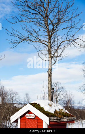 Overbygd, Norwegen. Kleine rote Plumpsklo mit natürlichen Dach. Stockfoto