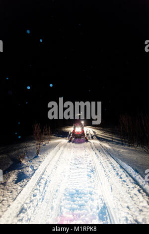 Skibotn, Norwegen. Schnee schneemobilfahren Aktion in der Nacht erschossen. Stockfoto