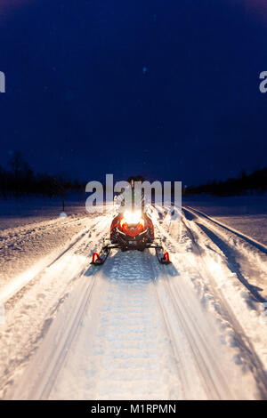 Skibotn, Norwegen. Schnee schneemobilfahren Aktion in der Nacht erschossen. Stockfoto