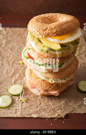 Auswahl an Sandwiches auf Bagels: Ei, Avocado, Schinken, Tomate, Weichkäse, Alfalfa Sprossen Stockfoto