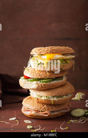 Auswahl an Sandwiches auf Bagels: Ei, Avocado, Schinken, Tomate, Weichkäse, Alfalfa Sprossen Stockfoto