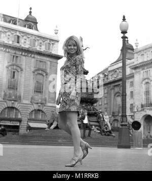 Ein Modell stellt in einem Mini Dress im Freien in Londons Piccadilly in der Nähe der Statue des Eros in ca. 1968 tragen eine bunte mini-kleid. Foto von Tony Henshaw Stockfoto