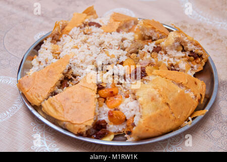 Shah Pilav. Khan Pilav in ein Fladenbrot. Traditionelle orientalische Schale. Auf Geschirr. Aserbaidschan, Baku. Shah Pilav mit Feuer auf einen Tisch im Restaurant. Stockfoto