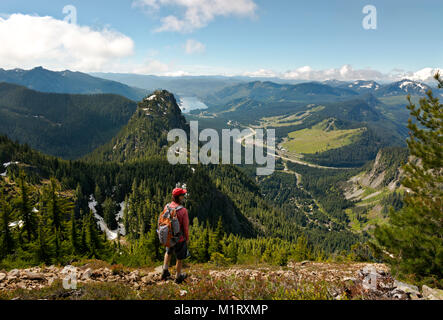 WA13197-00...WASHINGTON - Wanderer auf dem Weg zum Gipfel des Snoqualmie Mountain mit Blick auf Guye Peak, I-90 und das Snoqualmie Pass Recreation Area. Stockfoto