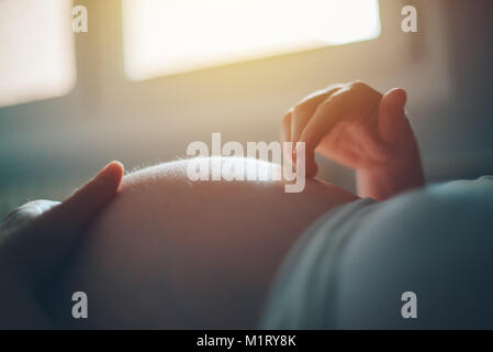 Schwangere Frau Bauch streicheln im Schlafzimmer zu Hause, kurz bevor die Wehen und Geburt, selektiven Fokus Stockfoto