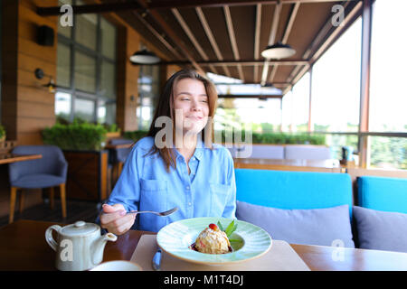 Europäische Mädchen trinken Kaffee im Restaurant und essen Kuchen. Stockfoto