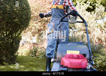 Nicht erkennbare Mann Drehen am Mähwerk Stockfoto