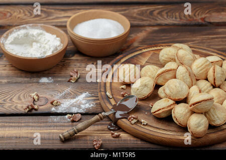 Hausgemachte Kekse, Nüsse mit Kondensmilch auf hölzernen Hintergrund. ländlichen Stil Stockfoto