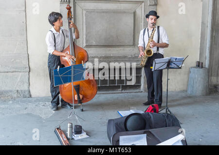 Zwei männliche Musiker spielen ein Cello und Saxophon in der Nähe der Uffizien in Florenz, Toskana, Italien. Stockfoto