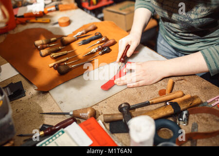 In der Nähe der Hände Tanner führt Arbeit auf Tabelle mit Tools Stockfoto