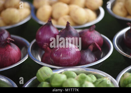 Gemüse mit Schalen mit frischem lila Farbe rote Zwiebeln und Kartoffeln im Hintergrund Abschaltdruck Stockfoto