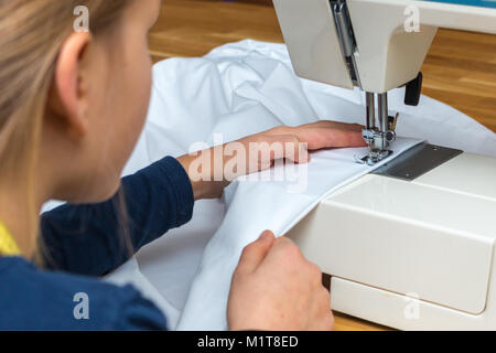 Ein 8 jähriges Mädchen ist das Nähen eines weißen Textilien Stockfoto