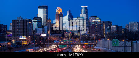 Dämmerung steigt auf Downtown Minneapolis, Minnesota, als aus dem Süden mit der Interstate 35 W im Vordergrund gesehen. Stockfoto