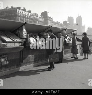 1950, historische, tagsüber in Paris, Frankreich, und Pariser durchsuchen Sie die antiquarische Bücher zum Verkauf entlang der Ufer der Seine durch die Stände der bouquinistes, die einzigartige Pariser aus zweiter Hand buch Verkäufer, eine Funktion von Paris leben seit Mitte-1500. Stockfoto