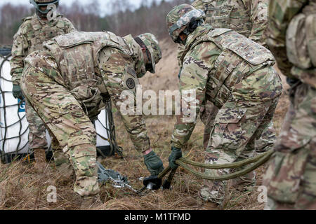 Soldaten der Brigade Support 299th Battalion, 2nd Brigade Combat Team, 1.Infanterie Division in Fort Riley, Kansas, bereiten Ausrüstung zu Schlinge werden von einem Hubschrauber in Skwierzyna, Polen am Jan. 4, 2017 geladen. Sling Laden ist eine Methode für den schnellen Transport von Geräten, die an der Unterseite von einem Hubschrauber mit einem Seil angebunden ist. (U.S. Armee Stockfoto