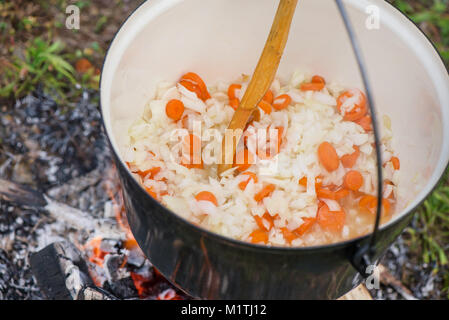 Kochen, heiße Gulaschsuppe mit Fleisch, Paprika, Kartoffeln, Zwiebeln, Karotten, traditionelle Gerichte der ungarischen Küche. Fleisch Eintopf in Römertopf zubereitet Stockfoto