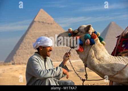 Ägypten, Kairo. Pyramiden von Gizeh oder Gizeh. Mann, Kamel Fahrer und sein Kamel in der Wüste in der Nähe von Pyramiden. Unesco-Weltkulturerbe. Stockfoto