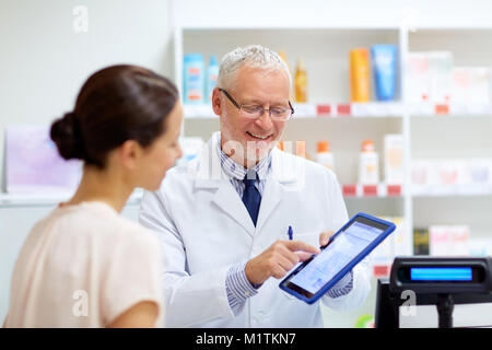 Apotheke und Kunden mit Tablet-PC in der Apotheke Stockfoto