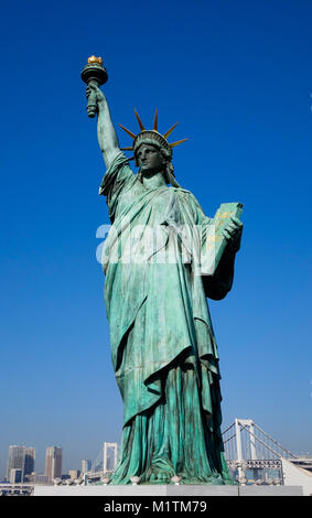 Nachbildungen der Freiheitsstatue mit stadtbild Hintergrund auf Odaiba Park in Tokio, Japan. Stockfoto