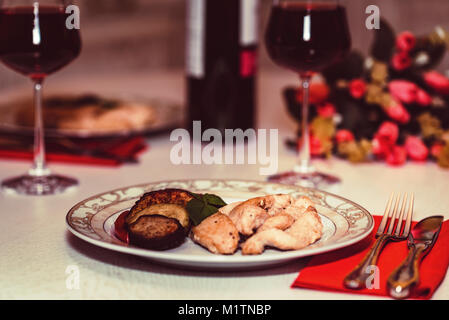 Romantisches Abendessen für Zwei mit Wein, Fleisch und Blumen Stockfoto