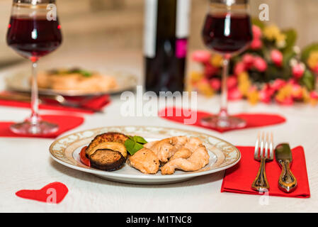 Romantisches Abendessen für Zwei mit Wein, Fleisch und Blumen Stockfoto