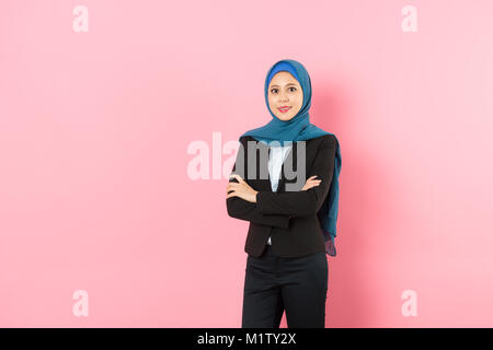 Professionelle zuversichtlich muslimischen Business frau Hände gekreuzt an Kamera und tragen Anzug Kleidung in rosa Hintergrund. Stockfoto