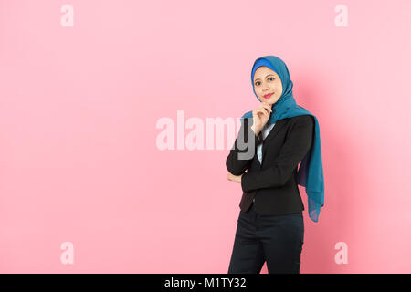 Schöne hübsche muslimischen weiblicher Manager stehen in rosa Hintergrund Gesicht zur Kamera zeigen zuversichtlich Business woman Konzept. Stockfoto
