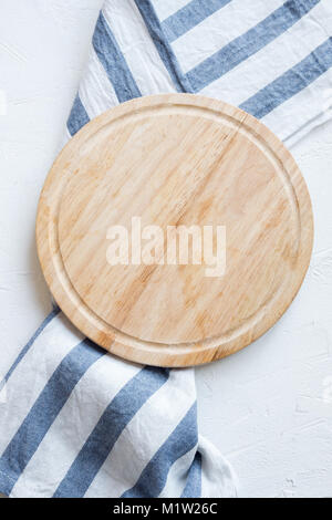 Leere Holz- platte mit Serviette auf weißen Stein Tabelle, Ansicht von oben, kopieren. Holz Schneidebrett über Weiß konkreten Hintergrund. Stockfoto