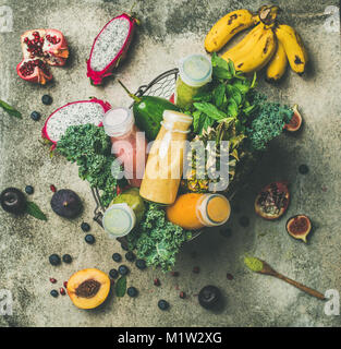 Bunte Smoothies in Flaschen mit frischem Obst im Korb Stockfoto