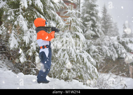 Glückliches Kind mit Foto Kamera Aufnahmen im Winter schneebedeckten Tag Stockfoto