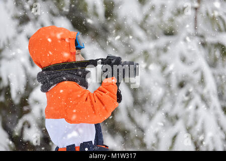 Glückliches Kind mit Foto Kamera Aufnahmen im Winter schneebedeckten Tag Stockfoto