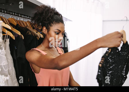 Weibliche Mode Designer beobachten ein Kleid in Ihrer mode Studio. Kunden Kleider in eine Boutique. Stockfoto