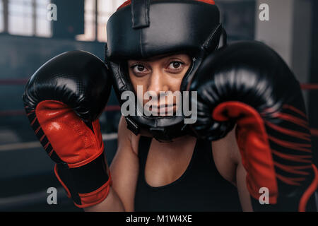 Nahaufnahme eines weiblichen Boxer in ihren Boxen. Frau Boxer an einem Boxen studio tragen Kopfschutz und Boxhandschuhen. Stockfoto