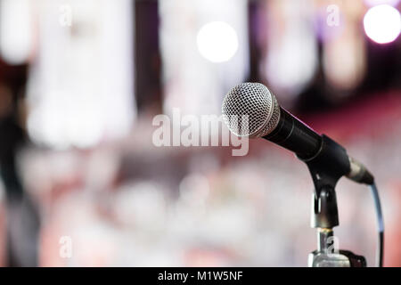 Mikrofon close-up. Fokus auf Mic. Abstrakte verschwommen Konferenzsaal oder Hochzeit Bankett auf Hintergrund. Veranstaltung Stockfoto