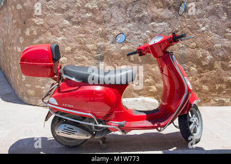 Eine rote Vespa LX 150 scooter durch die Wand geparkt, Altstadt, Rethymnon (Rethymno), Rethymno, Kreta (Kriti), Griechenland Stockfoto